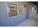 Exterior shot of the side of a condo unit, painted gray with an orange door and a lantern-style light at 10263 Gandy N Blvd # 105, St Petersburg, FL 33702