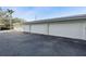 Row of numbered garages with white doors and gray trim against a dark asphalt driveway at 1036 N Shore Ne Dr # 5, St Petersburg, FL 33701