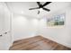Bedroom with wood floors, white walls, ceiling fan, and bright window at 1125 Fairwood Ave, Clearwater, FL 33759