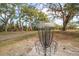 Community disc golf basket amidst a lush, tree-filled park setting, a fun and engaging outdoor activity at 1125 Fairwood Ave, Clearwater, FL 33759