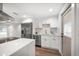 Bright kitchen featuring stainless steel appliances, white cabinetry, and a large center island with marble countertops at 1125 Fairwood Ave, Clearwater, FL 33759