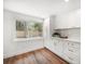 Bright kitchen features white cabinets, gold hardware and wood flooring at 1125 Fairwood Ave, Clearwater, FL 33759
