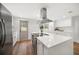 Bright kitchen features white cabinets, stainless steel appliances, and a spacious quartz countertop island at 1125 Fairwood Ave, Clearwater, FL 33759