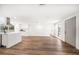 Spacious empty living room with hardwood flooring, neutral paint, and natural light leading to the kitchen at 1125 Fairwood Ave, Clearwater, FL 33759