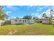 Backyard featuring a well maintained lawn and an exterior view of the home at 1140 7Th Ne Ave, Largo, FL 33770