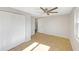 This bedroom has light walls, vinyl flooring, a ceiling fan, a large closet, and a view into the hallway at 1140 7Th Ne Ave, Largo, FL 33770