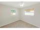 This bedroom has neutral walls, carpeted floors, and lots of natural light through two windows at 1140 7Th Ne Ave, Largo, FL 33770