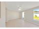 Bright living room with tile flooring, neutral walls, a ceiling fan, and access to the outdoors through a glass door at 1140 7Th Ne Ave, Largo, FL 33770