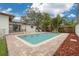 Enjoy the refreshing pool with brick patio, tropical landscaping, and ample seating for relaxation and entertaining at 121 Shirley Dr, Largo, FL 33770