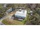 A high angle captures a light blue home with a metal roof nestled among mature trees and open lawn space at 12322 Eagle Lake Ave, New Port Richey, FL 34654