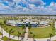 Aerial view of a community clubhouse, playground, pool and surrounding neighborhood, all under a beautiful blue sky at 16126 Sunday Stroll Way, Odessa, FL 33556