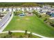 Aerial view of community green space featuring lush lawn, playground, and picnic shelter at 16126 Sunday Stroll Way, Odessa, FL 33556