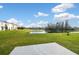 Spacious backyard with green grass, pond, and neighborhood view creates a peaceful outdoor retreat at 16126 Sunday Stroll Way, Odessa, FL 33556