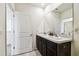 Bathroom featuring double sinks, a granite countertop, and dark brown cabinets at 16126 Sunday Stroll Way, Odessa, FL 33556
