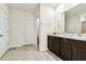 Bright bathroom featuring double sinks, a granite countertop, and dark brown cabinets at 16126 Sunday Stroll Way, Odessa, FL 33556