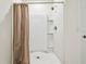 Bright white bathroom features a shower and light brown curtain for added privacy at 16126 Sunday Stroll Way, Odessa, FL 33556