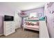 bedroom with bunk beds, a TV, and decorations on light purple walls at 16126 Sunday Stroll Way, Odessa, FL 33556