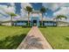 Community clubhouse featuring a brick walkway, lush landscaping, and bright blue siding at 16126 Sunday Stroll Way, Odessa, FL 33556