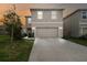Charming home featuring a two-car garage, manicured lawn, and neutral color palette at sunset at 16126 Sunday Stroll Way, Odessa, FL 33556