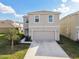 Two-story home features a two-car garage and manicured lawn at 16126 Sunday Stroll Way, Odessa, FL 33556