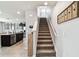 View of the staircase with carpeted steps, white railing, and open access to the kitchen area at 16126 Sunday Stroll Way, Odessa, FL 33556