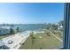 An outdoor pool with an ocean view, surrounded by palm trees and lounge chairs at 1868 Shore S Dr # 602, South Pasadena, FL 33707