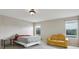 Bright bedroom features a bed, yellow sofa, neutral walls, and windows offering outdoor views at 20115 Nob Oak Ave, Tampa, FL 33647