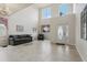 Bright living room featuring high ceilings, tiled floors, contemporary furnishings, and a decorative front door at 20115 Nob Oak Ave, Tampa, FL 33647