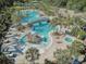 Resort-style pool featuring a water slide, splash zone, and a connecting bridge, surrounded by palm trees at 20115 Nob Oak Ave, Tampa, FL 33647