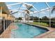 Screened-in pool with brick trim and a view of the lake beyond the backyard at 20115 Nob Oak Ave, Tampa, FL 33647