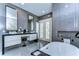 Contemporary bathroom boasts dual sinks, sleek gray tile, soaking tub, and access to the outdoors at 2113 S West Shore Blvd, Tampa, FL 33629