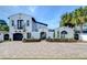 Elegant white home showcasing a brick driveway, meticulous landscaping, and mature palm trees at 2113 S West Shore Blvd, Tampa, FL 33629
