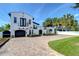Charming two-story home with a brick driveway, black garage door, and lush landscaping at 2113 S West Shore Blvd, Tampa, FL 33629