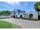 Beautiful white home with a spacious brick driveway and well-maintained landscaping at 2113 S West Shore Blvd, Tampa, FL 33629