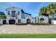Beautiful white home showcasing a brick driveway, manicured landscaping, and mature palm trees at 2113 S West Shore Blvd, Tampa, FL 33629