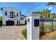 Beautiful home with a brick driveway and iron gate, complemented by lush landscaping and palm trees at 2113 S West Shore Blvd, Tampa, FL 33629
