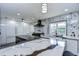 Modern kitchen featuring marble countertops and backsplash, white cabinets, stainless steel appliances and natural light at 2113 S West Shore Blvd, Tampa, FL 33629