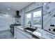 Modern kitchen showcasing marble countertops and backsplash, white cabinets, stainless steel appliances, and garden view at 2113 S West Shore Blvd, Tampa, FL 33629