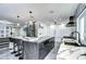 Modern kitchen with marble countertops, a wine rack, stainless steel appliances, and three bar stools for countertop seating at 2113 S West Shore Blvd, Tampa, FL 33629