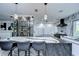 Modern kitchen with marble countertops, a wine rack, stainless steel appliances, and three bar stools for countertop seating at 2113 S West Shore Blvd, Tampa, FL 33629