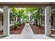 Framed view into the lushly landscaped courtyard with garden, mature palms, and walking path at 212 S Church Ave # 208, Tampa, FL 33609