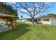 A spacious backyard featuring a gazebo with a manicured lawn and landscaping at 2146 Society Dr, Holiday, FL 34691