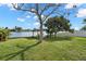 Large backyard featuring mature landscaping, a gazebo, and waterfront access at 2146 Society Dr, Holiday, FL 34691