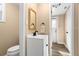 Half bathroom featuring a modern sink, a gold-trimmed mirror, and views into an adjacent utility area at 2146 Society Dr, Holiday, FL 34691