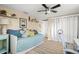 Bright secondary bedroom featuring daybed, ceiling fan, shelving and laminate floors at 2146 Society Dr, Holiday, FL 34691