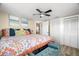 Bright bedroom featuring colorful bedding, a ceiling fan, closet, and ensuite access at 2146 Society Dr, Holiday, FL 34691
