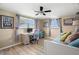 Guest bedroom featuring natural light, ceiling fan, laminate floors, and a desk at 2146 Society Dr, Holiday, FL 34691