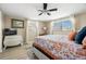 Cozy bedroom with a patterned bedspread, ceiling fan, and sunny windows at 2146 Society Dr, Holiday, FL 34691