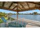 Waterfront covered dock featuring a ceiling fan and swim ladder, providing a relaxing space by the water at 2146 Society Dr, Holiday, FL 34691