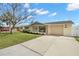 Charming single-story home with a well-maintained lawn, showcasing a long driveway and attached garage at 2146 Society Dr, Holiday, FL 34691